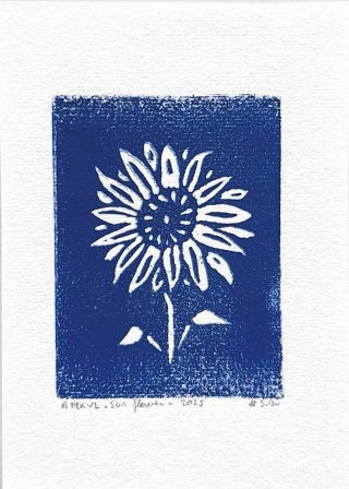 A blue linocut of a sunflower. The sunflower is white and all around it is blue.